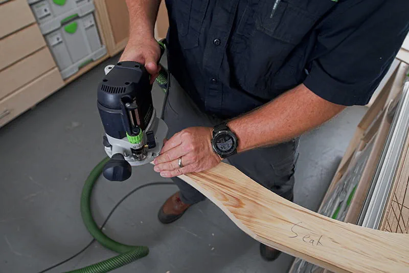 Brent using a router on a piece of wood