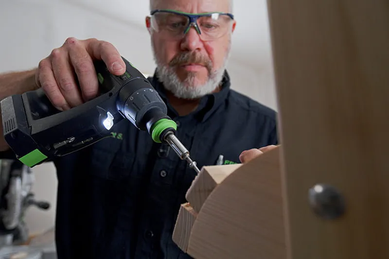 Brent using a screwdriver to secure wood
