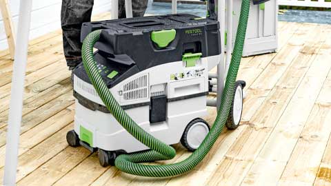 An industrial vacuum is positioned on a terrace with a parquet floor.